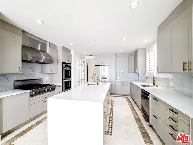 a large kitchen with stainless steel appliances granite countertop a stove a sink a refrigerator and a microwave