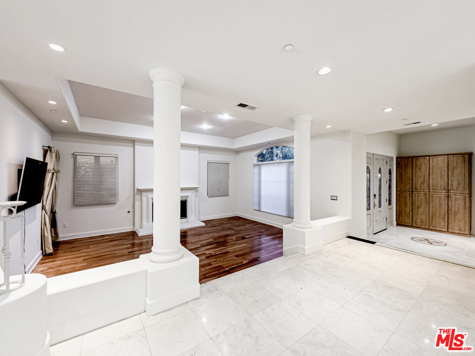 12626 Promontory Road Los Angeles, CA 90049 - Photo 6 of 34 a large bedroom with a large bed and a chandelier