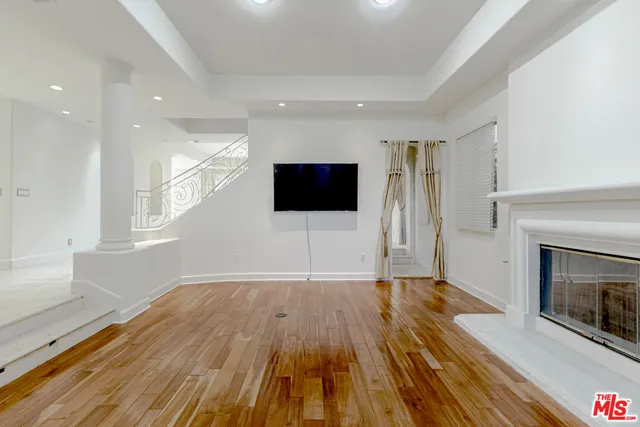 a view of empty room with wooden floor and fireplace