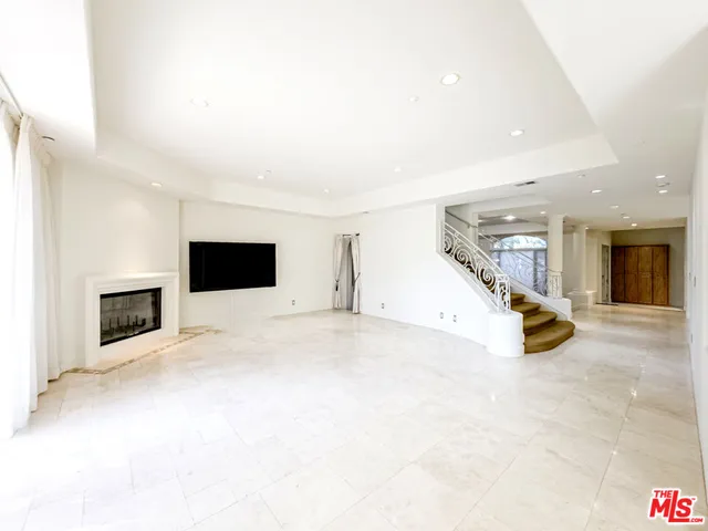 a view of an empty room with fireplace and a window