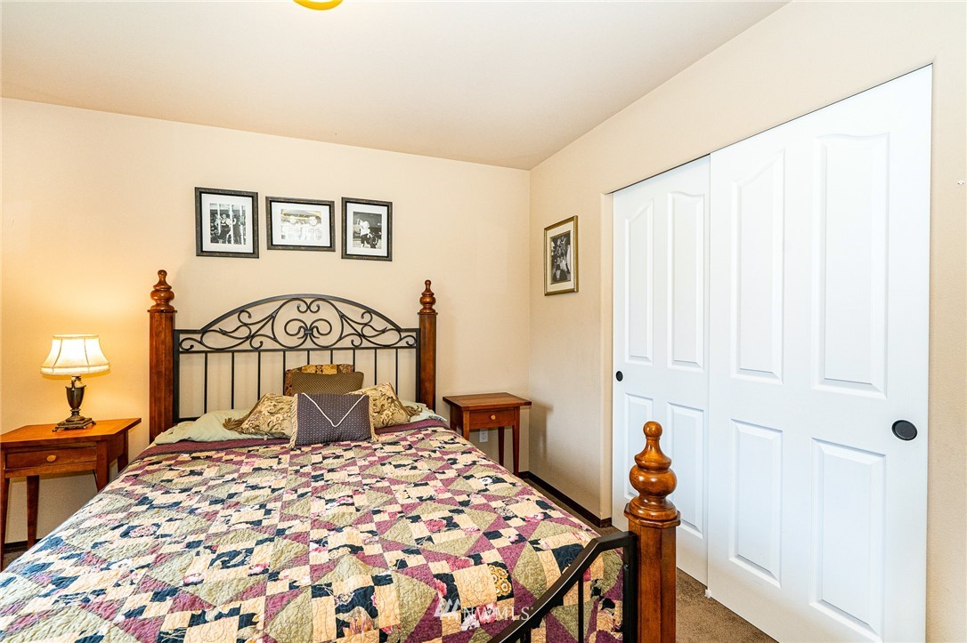 5120 180th Trail Southwest Rochester, WA 98579 - Photo 26 of 32 a bedroom with a bed and a chandelier