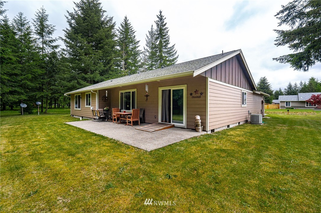 5120 180th Trail Southwest Rochester, WA 98579 - Photo 7 of 32 a view of a house with a patio and a yard