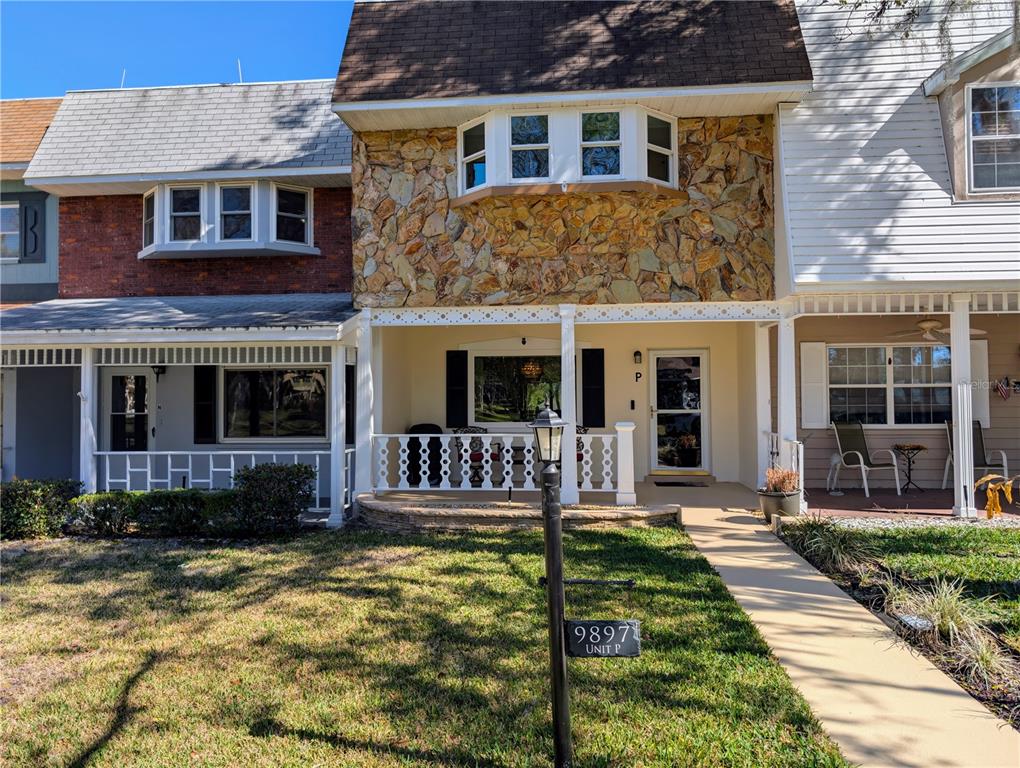 9897 Southwest 88th Court Road, Unit P Ocala, FL 34481 - Photo 1 of 35 a front view of a house with yard walls and floor to ceiling window