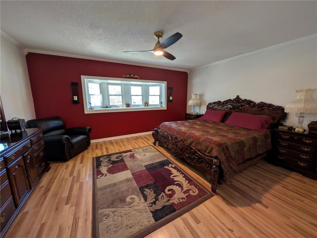 9897 Southwest 88th Court Road, Unit P Ocala, FL 34481 - Photo 17 of 35 a bedroom with a bed and wooden floor