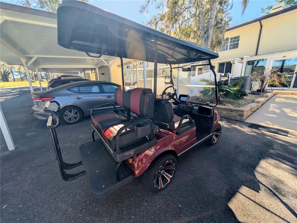 9897 Southwest 88th Court Road, Unit P Ocala, FL 34481 - Photo 32 of 35 a view of a patio with table and chairs under an umbrella with a barbeque