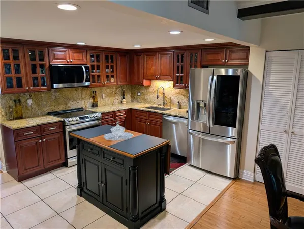a kitchen with stainless steel appliances granite countertop a stove a sink and a refrigerator