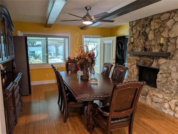 a dining room with furniture a fireplace and wooden floor