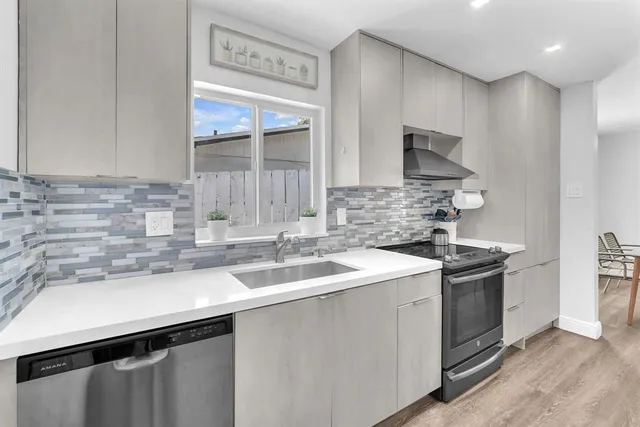 a kitchen with a sink stove top oven and cabinets