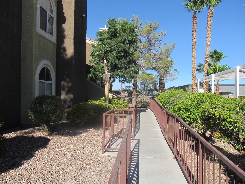 7950 West Flamingo Road, Unit 2048 Las Vegas, NV 89147 - Photo 3 of 24 An inviting, accessible pathway guides visitors past verdant landscaping to the property's entrance.