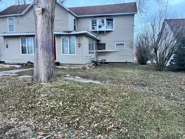 a view of a house with a yard and large tree