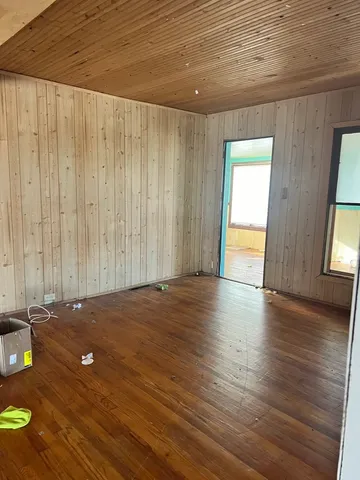 a view of a room with wooden floor and window