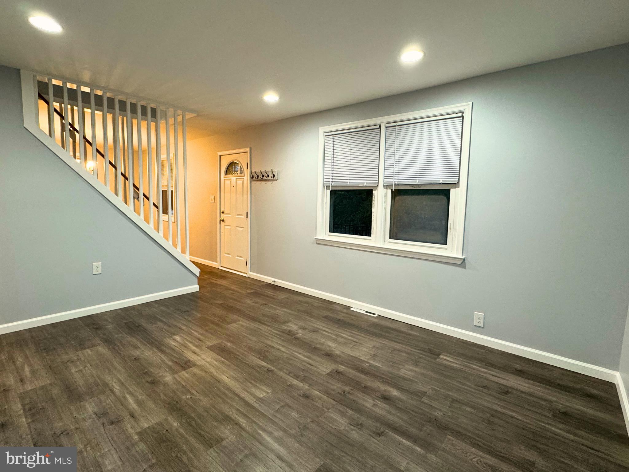 2909 Duncan Lane Parkville, MD 21234 - Photo 4 of 20 a view of an empty room with wooden floor and a window