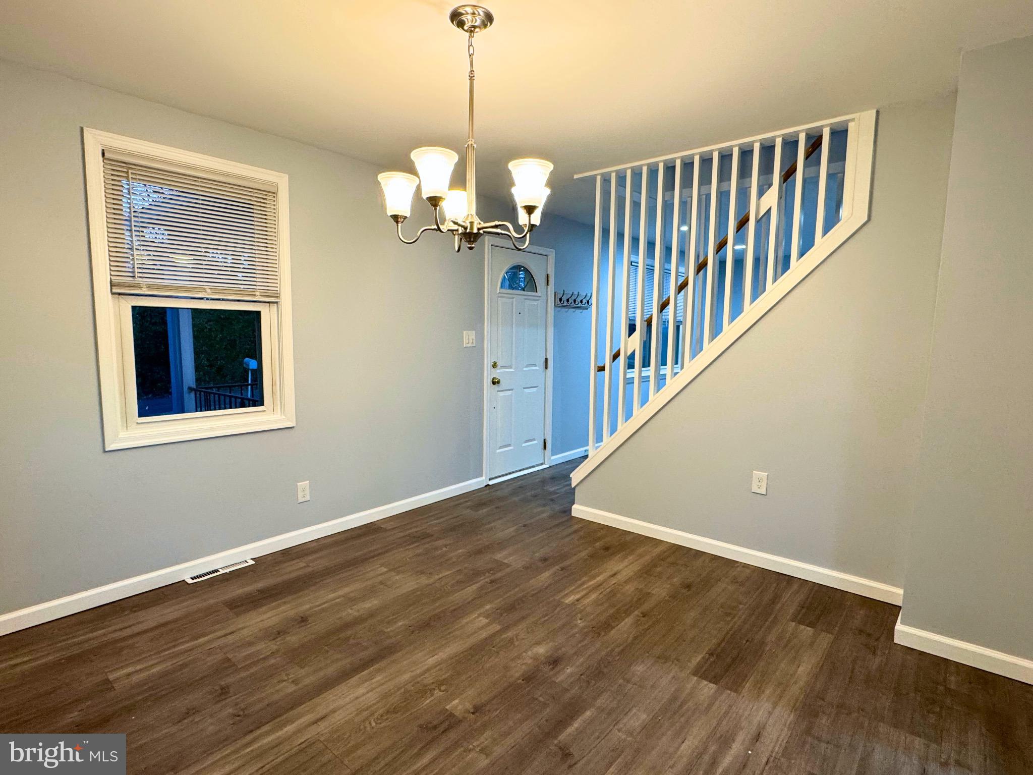 2909 Duncan Lane Parkville, MD 21234 - Photo 6 of 20 a view of an empty room with wooden floor and a window