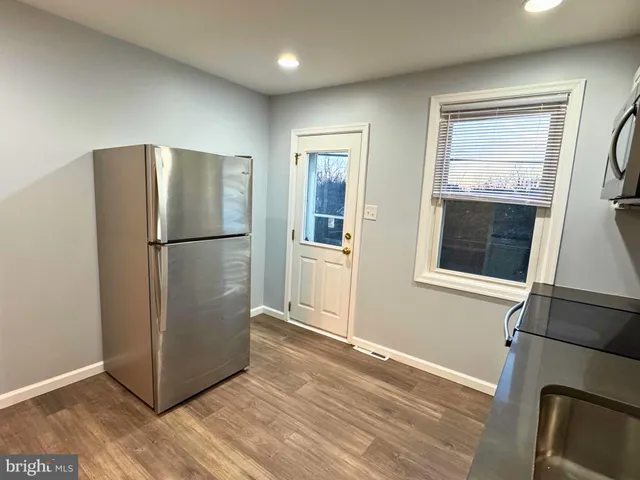 a view of a refrigerator in kitchen and wooden floor