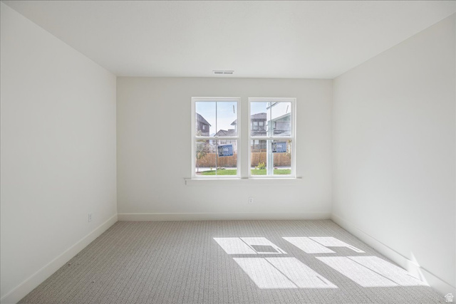 7189 South Sage Road, Unit 214 West Jordan, UT 84081 - Photo 27 of 29 Bright interior room featuring a large double window, light gray patterned carpeting, white painted walls, and white trim