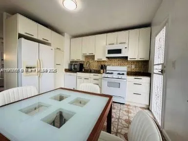 a kitchen with white cabinets sink and stainless steel appliances