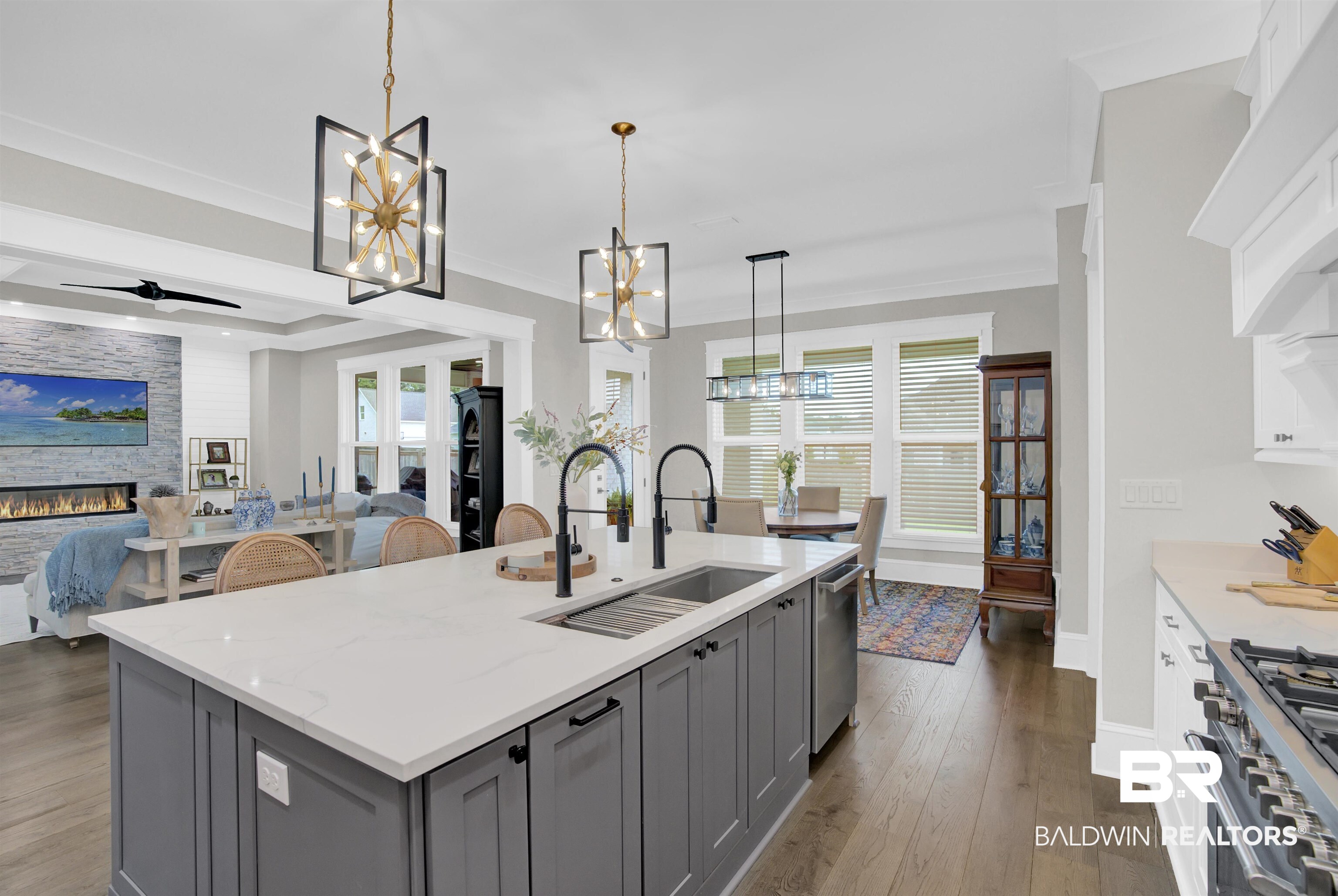 10940 Atrium Avenue Fairhope, AL 36532 - Photo 14 of 43 Kitchen featuring a stone fireplace, sink, gray cabinets, light stone countertops, and stainless steel appliances