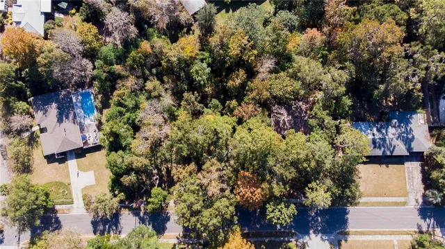 an aerial view of residential houses with outdoor space and trees
