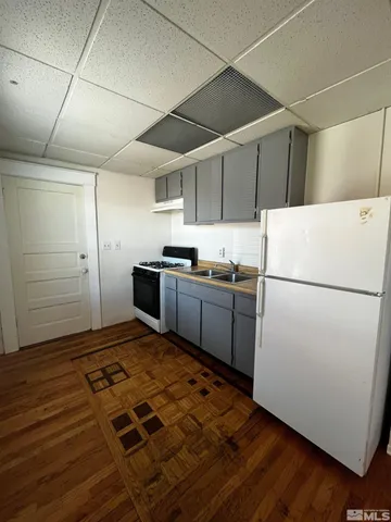 a kitchen with wooden cabinets and white appliances