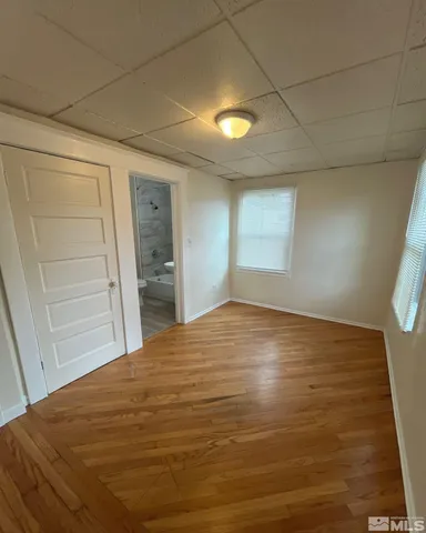 a view of empty room with wooden floor