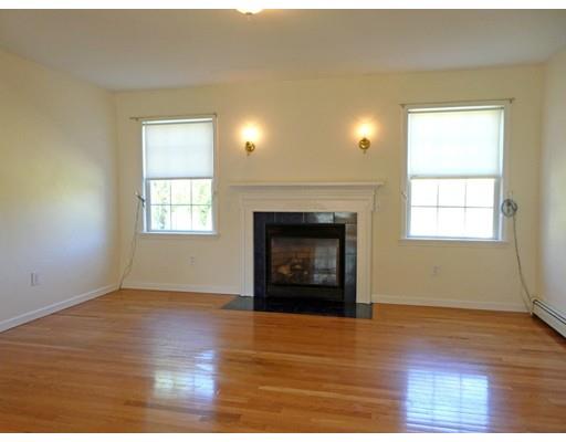 261 Cushman Road Rochester, MA 02770 - Photo 17 of 25 an empty room with wooden floor fireplace and windows