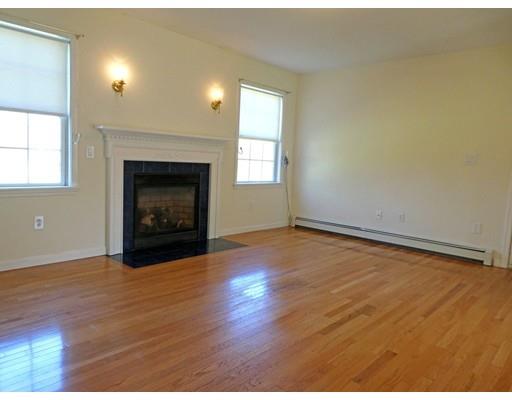 261 Cushman Road Rochester, MA 02770 - Photo 18 of 25 an empty room with wooden floor fireplace and windows