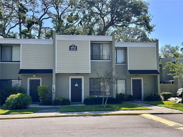 a view of a house with a yard and tree s