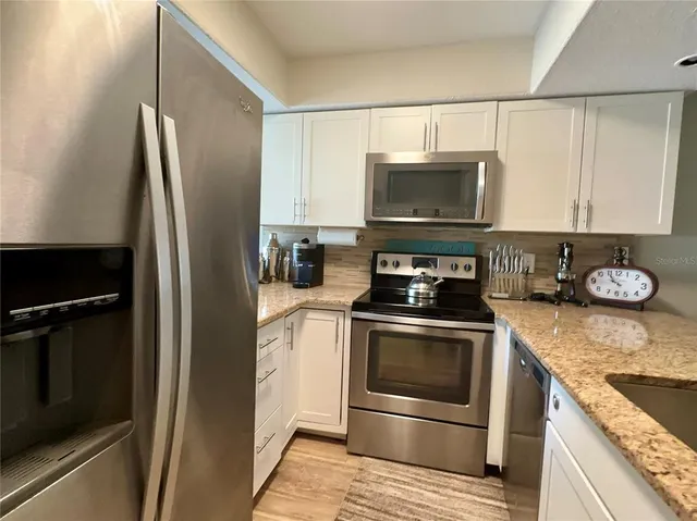 a kitchen with granite countertop stainless steel appliances and wooden cabinets