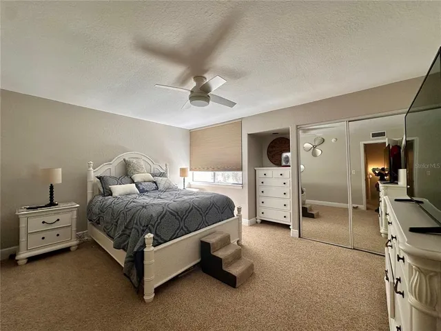 a spacious bedroom with a bed and a cabinets