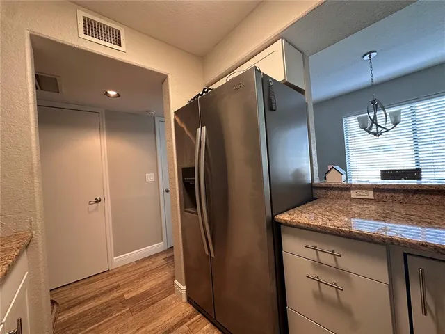 a kitchen with stainless steel appliances granite countertop a refrigerator and a sink