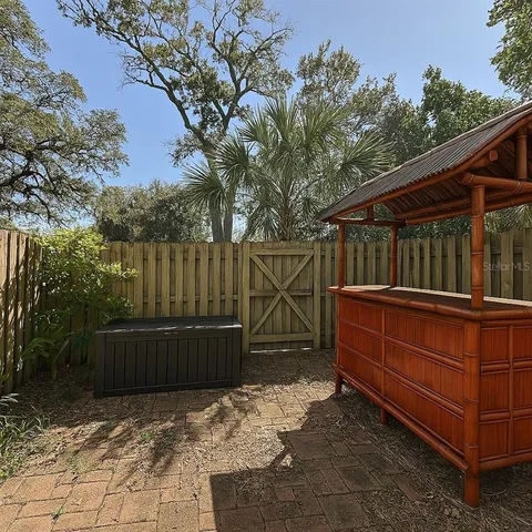 a view of backyard with wooden fence and large trees