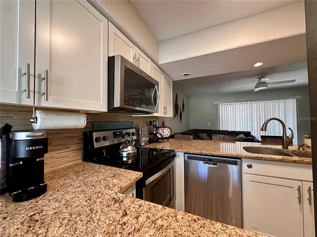 a kitchen with a sink a stove top oven and cabinets