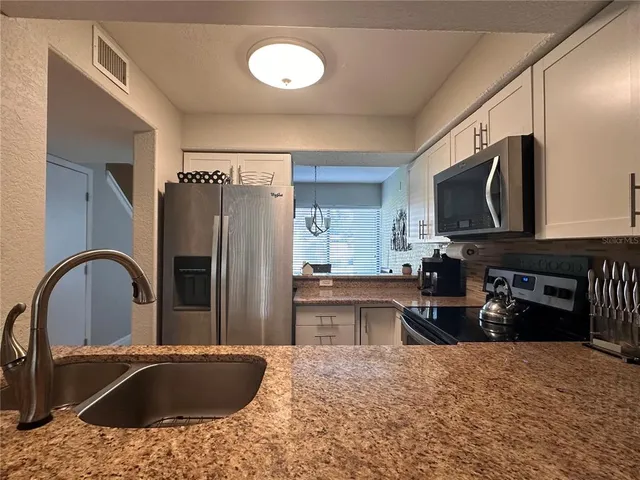a kitchen with granite countertop a stove and a sink