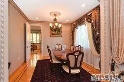 a dining room with furniture a chandelier and wooden floor