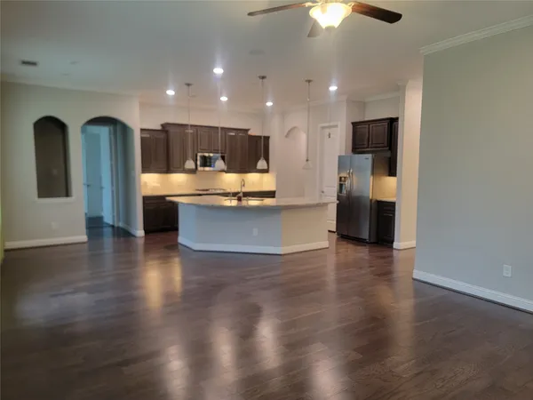 a kitchen with stainless steel appliances granite countertop a sink a microwave a refrigerator and white cabinets