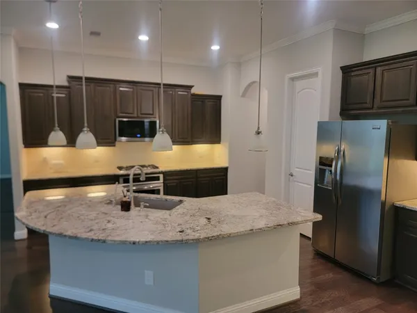a view of a kitchen with a sink a fireplace and wooden floor