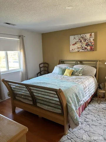 a bedroom with a bed and painting on the wall