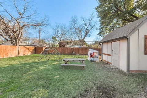 a backyard of a house with table and chairs
