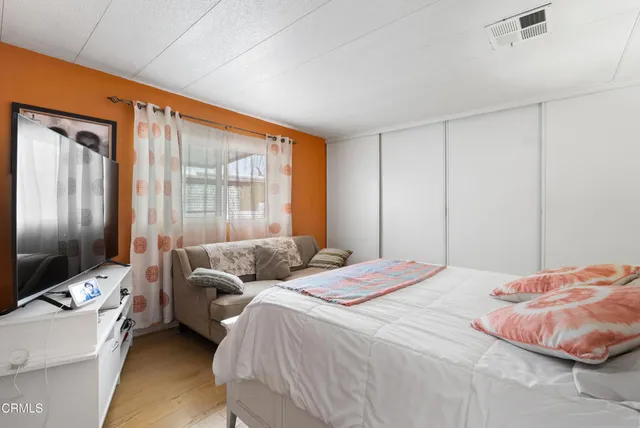 a bedroom with bed couch and window