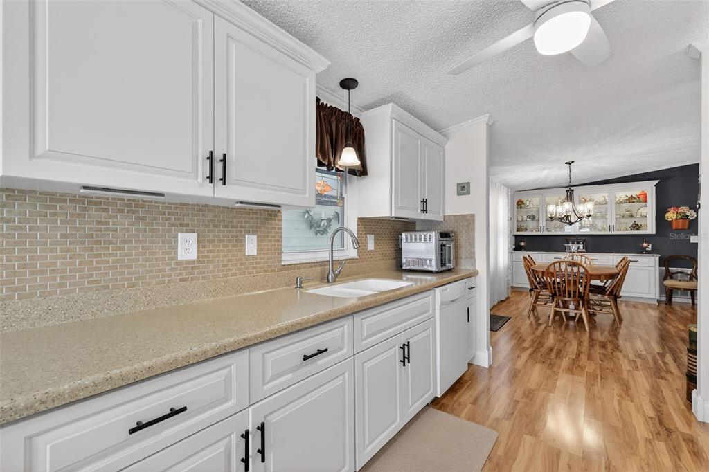 469 Santa Fe Road Tavares, FL 32778 - Photo 15 of 37 a kitchen with white cabinets and wooden floor
