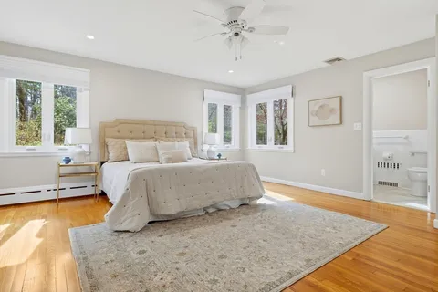 a bedroom with a large bed and wooden floor