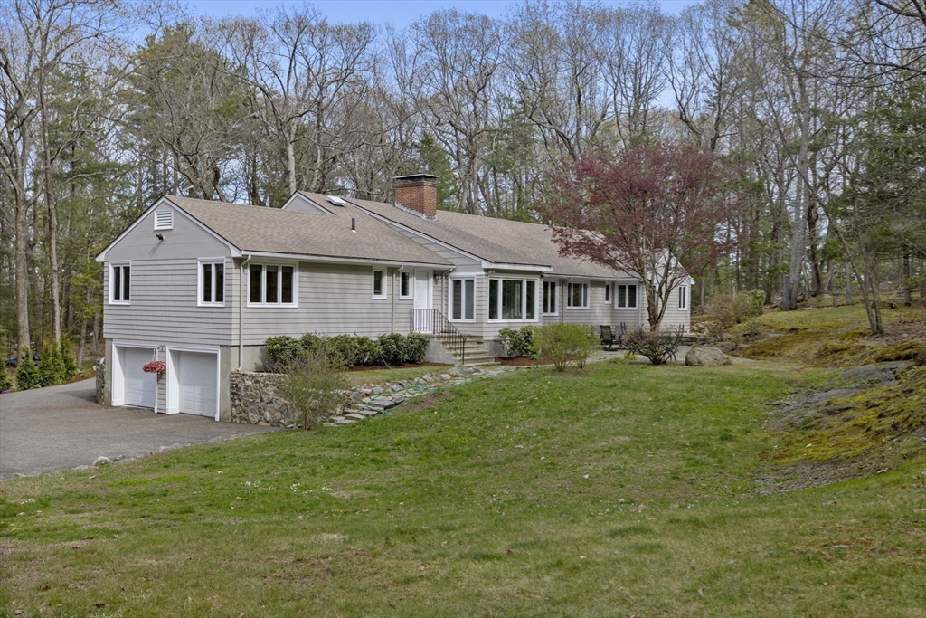 31 Huckleberry Hill Road Lincoln, MA 01773 - Photo 25 of 27 a front view of a house with a garden and trees