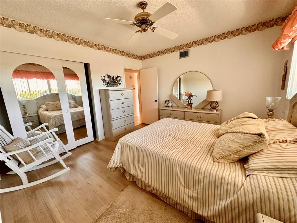 2340 Grecian Way, Unit 56 Clearwater, FL 33763 - Photo 12 of 40 a bedroom with a bed and a chandelier