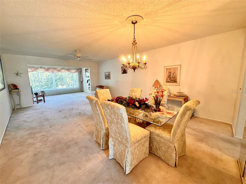 2340 Grecian Way, Unit 56 Clearwater, FL 33763 - Photo 3 of 40 a view of a dining room with furniture wooden floor and chandelier