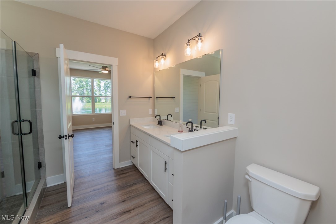 36458 Appian Way North Ridgeville, OH 44039 - Photo 19 of 37 Bathroom featuring toilet, walk in shower, vanity, wood-type flooring, and ceiling fan