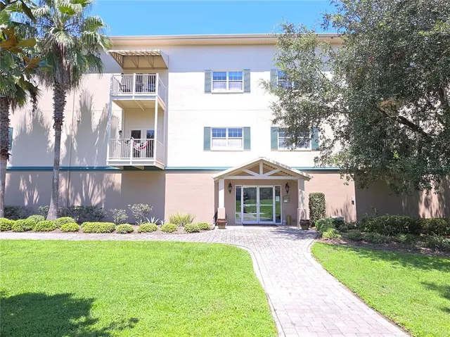 a front view of a house with a yard and potted plants