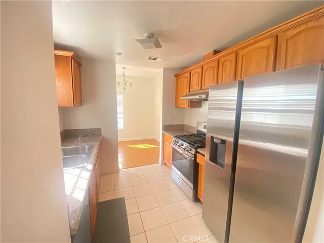 a kitchen with stainless steel appliances granite countertop a refrigerator and a sink