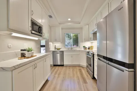 a kitchen with a sink appliances cabinets and a counter top space