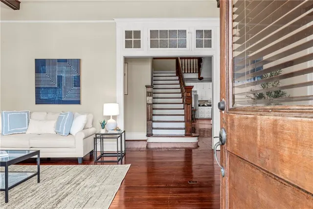 a living room with hardwood floor and a potted plant