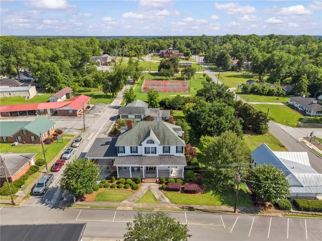 an aerial view of a house with a garden and lake view
